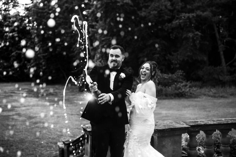 Devon and Adam popping champagne bottle at Inglewood Manor House Wedding Venue