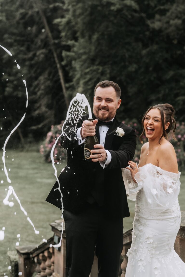 Devon and Adam popping champagne bottle at Inglewood Manor House Wedding Venue